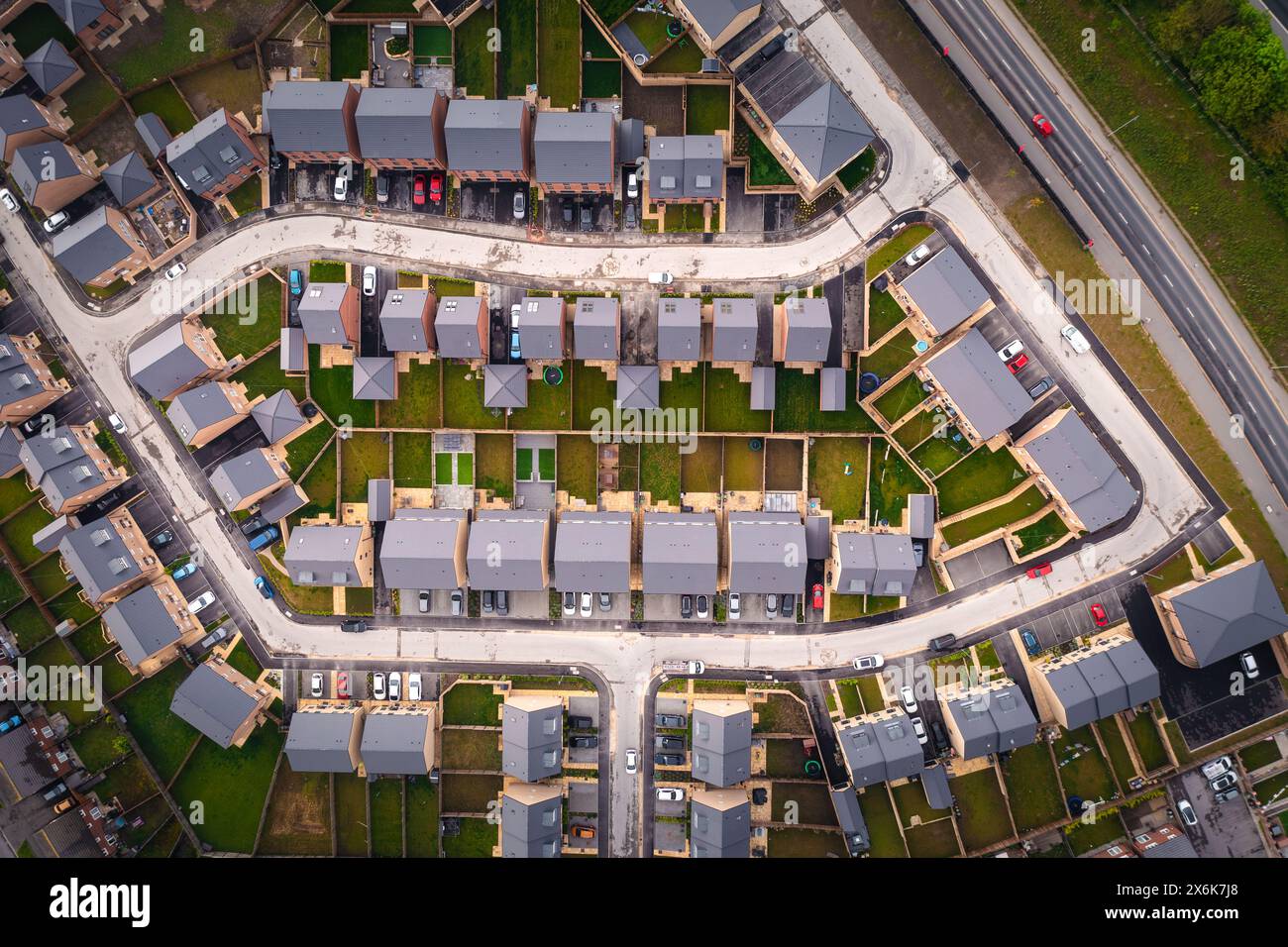 Blick von oben nach unten über einem Block neu gebauter Vorstadthäuser in Großbritannien mit kleinen Gärten Stockfoto