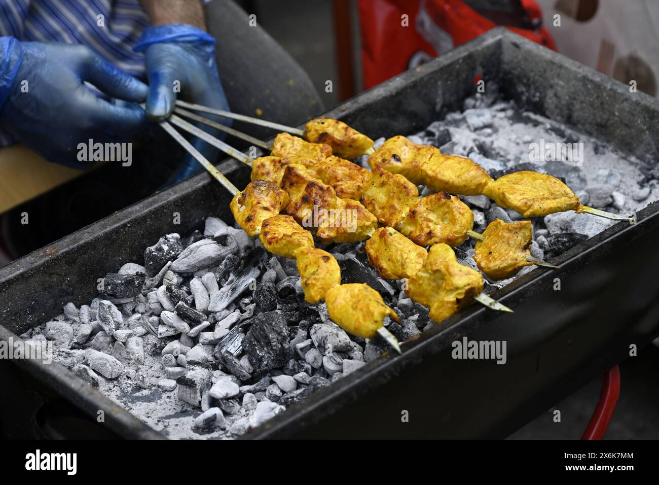 Hähnchenstücke auf Spießen, die über Holzkohlegrill gekocht werden Stockfoto