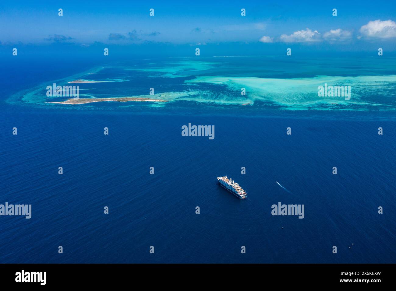 Aus der Vogelperspektive des Expeditionskreuzfahrtschiffs SH Diana (Swan Hellenic) mit Riff dahinter, Cosmoledo Atoll, Äußere Seychellen, Seychellen, Indischer Ozean Stockfoto
