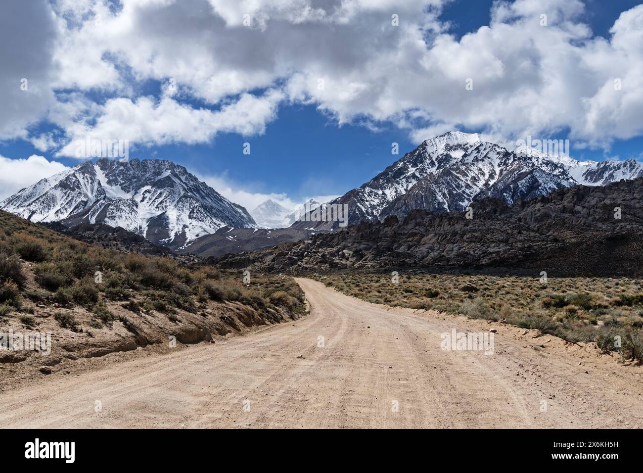 Eine Schotterstraße führt in Richtung der Sierra Nevada Mountains und der Buttermilks Stockfoto