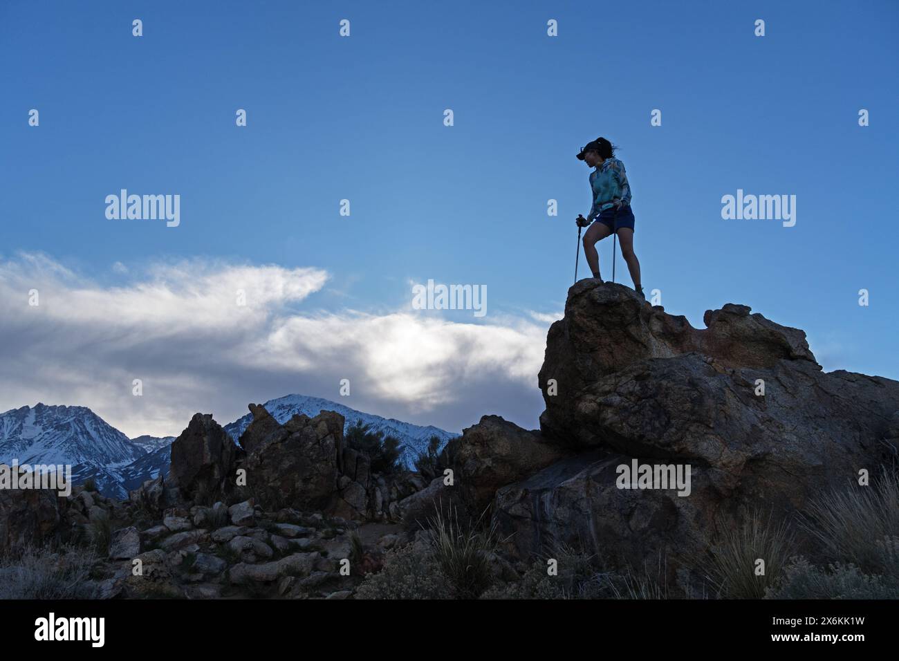 Eine aktive Erwachsene Frau mit Wanderstöcken erreicht den Gipfel eines windigen Tungsten Peaks im Owens Valley bei Bishop California Stockfoto