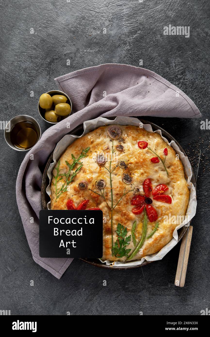 Blumenmalerei Focaccia, italienische Gartenfladenbrotkunst mit Tomaten, Zwiebeln und Petersilie auf dunklem Hintergrund. Draufsicht. Stockfoto