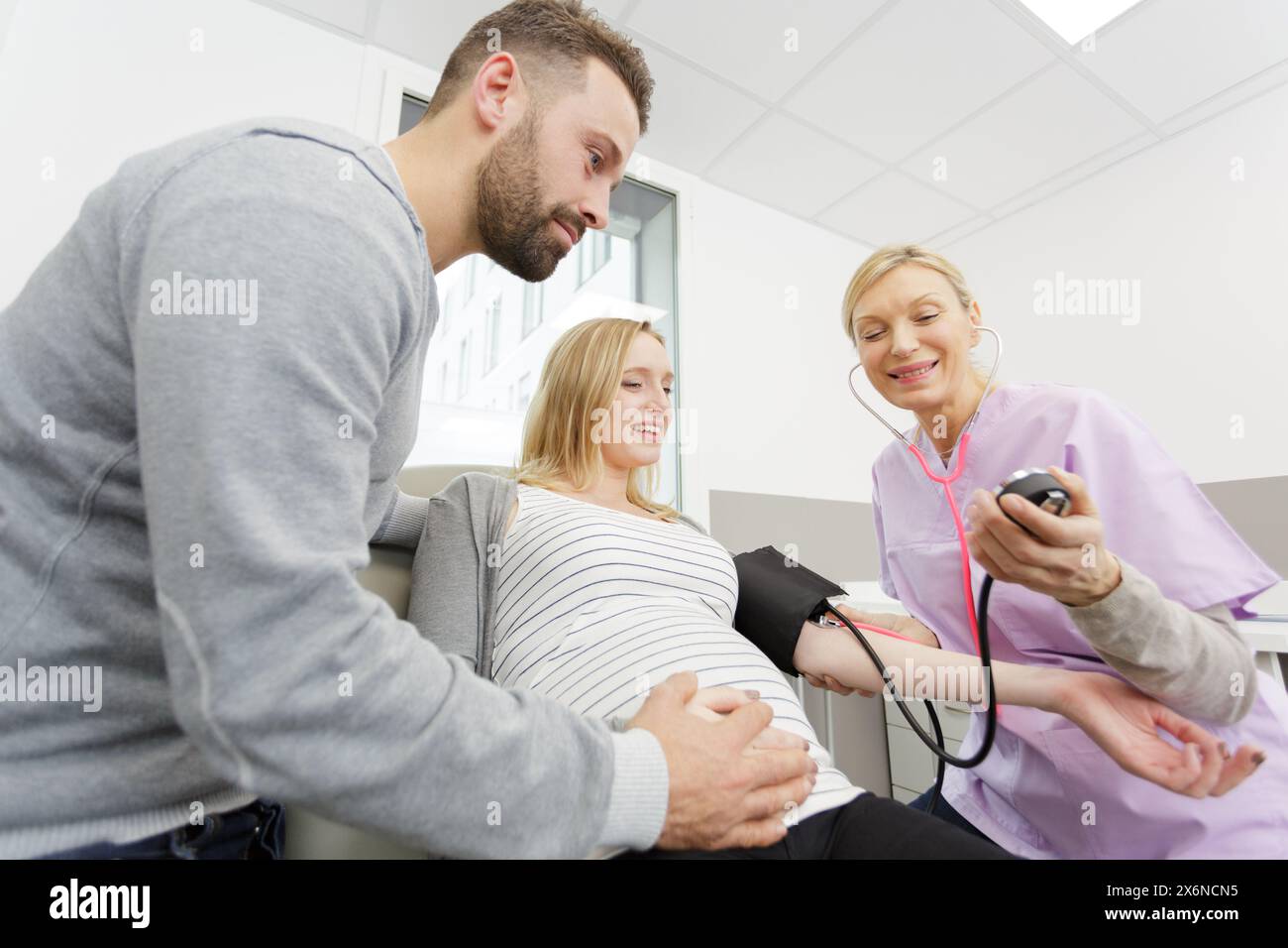 Schwangere Paare bei Ultraschalluntersuchungen zur Blutdruckmessung Stockfoto