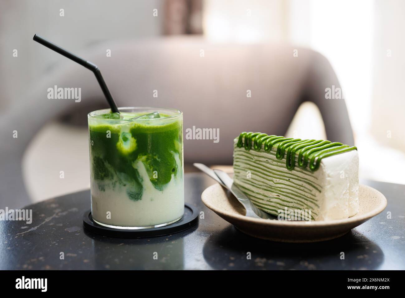 Matcha Green Tea Süßigkeiten und Getränke werden im Café serviert, grüner Kreppkuchen und grüner Eistee in der Nähe auf dem Tisch. Stockfoto