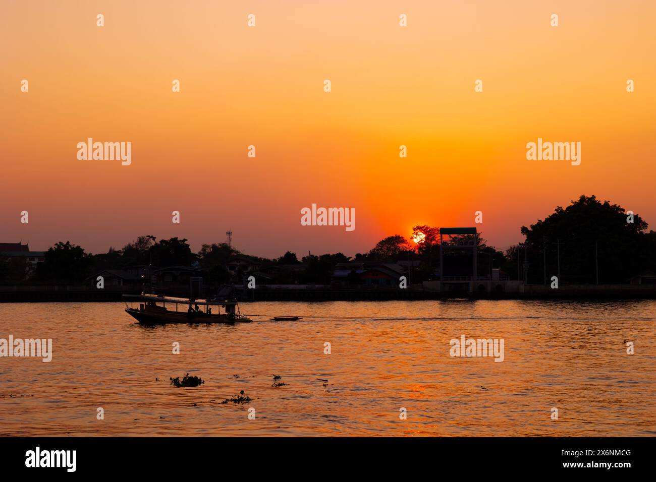 Blick auf den Fluss bei Sonnenuntergang mit orangefarbenem Himmel. Abendliche Silhouette Boot ruhige ruhige Chaophraya Flusslandschaft Stockfoto