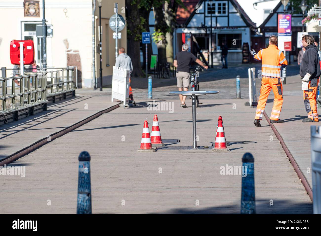 Drehbrücke Seebad Warnemünde Blick auf das aufgesteckte Rad der Öffnungsmechanik der Drehbrücke in Warnemünde. An der denkmalgeschützten Brücke im Ostseebad werden derzeit Reparaturarbeiten durchgeführt. Für die Drehung der Brücke muss das Bauwerk dann für den Fußgängerverkehr zeitweise voll gesperrt werden. Bahnhofsbrücke Warnemünde. Die Bahnhofsbrücke im Ostseebad Warnemünde verbindet über den Alten Strom hinweg den Warnemünder Bahnhof auf der Mittelmole und den westlichen gelegenen Ortskern. Rostock Warnemünde *** Schaukelbrücke Warnemünde Badeort Blick auf das befestigte Rad der Öffnung Stockfoto