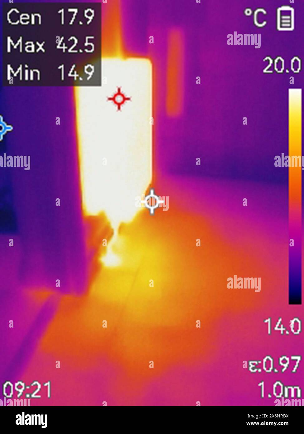 Lecksuche mit Wärmebildkamera. Infrarotaufnahme eines Heizkörpers und einer Wärmewolke im Boden aufgrund einer Leckage in einer Heißwasserleitung. Zentrale Heizung Stockfoto