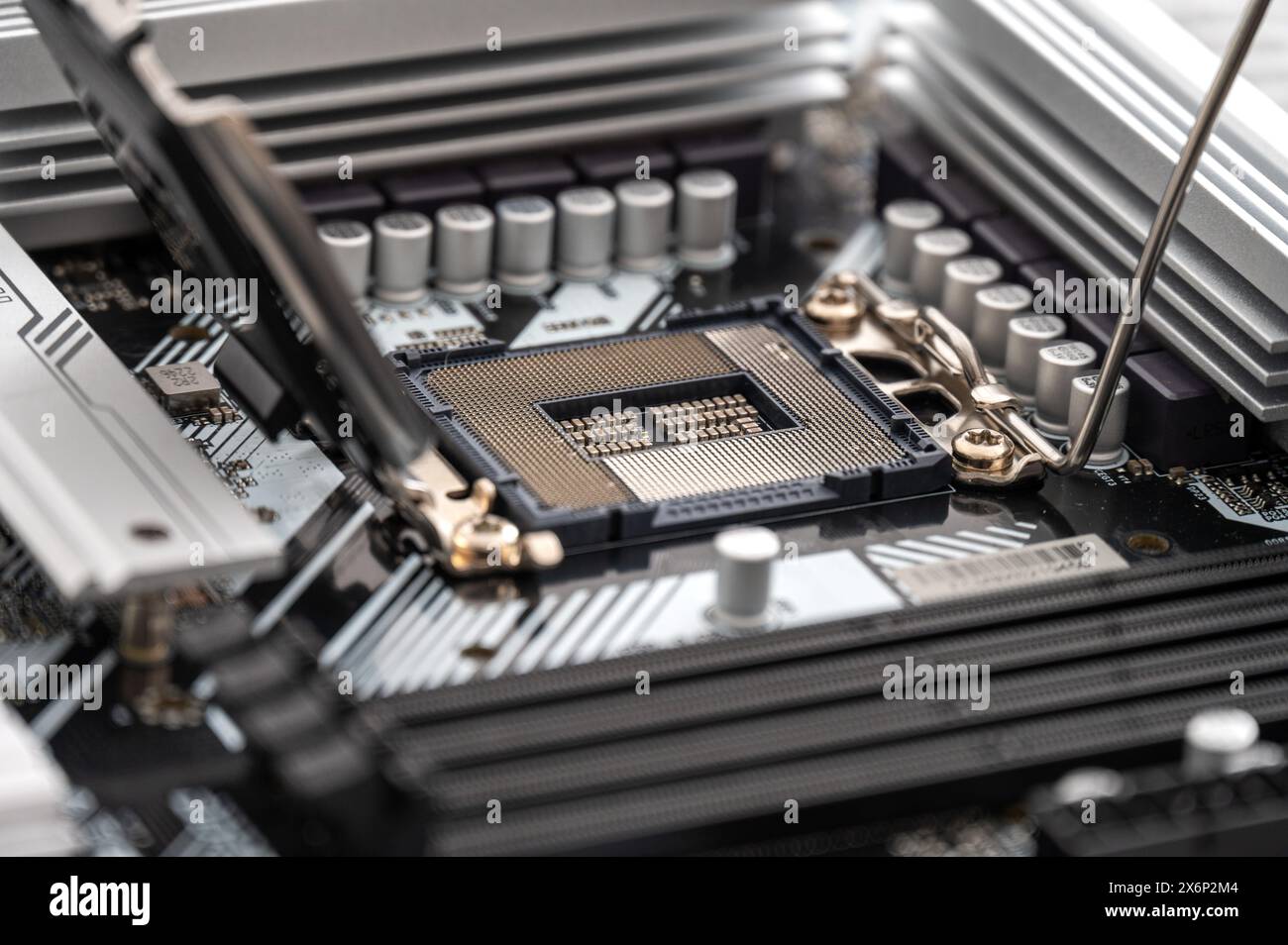 Dramatische Winkel erfasst ein modernes Computermotherboard und hebt den CPU-Sockel (Central Processing Unit) hervor, der von Kondensatoren, RAM-Steckplätzen und umgeben ist Stockfoto