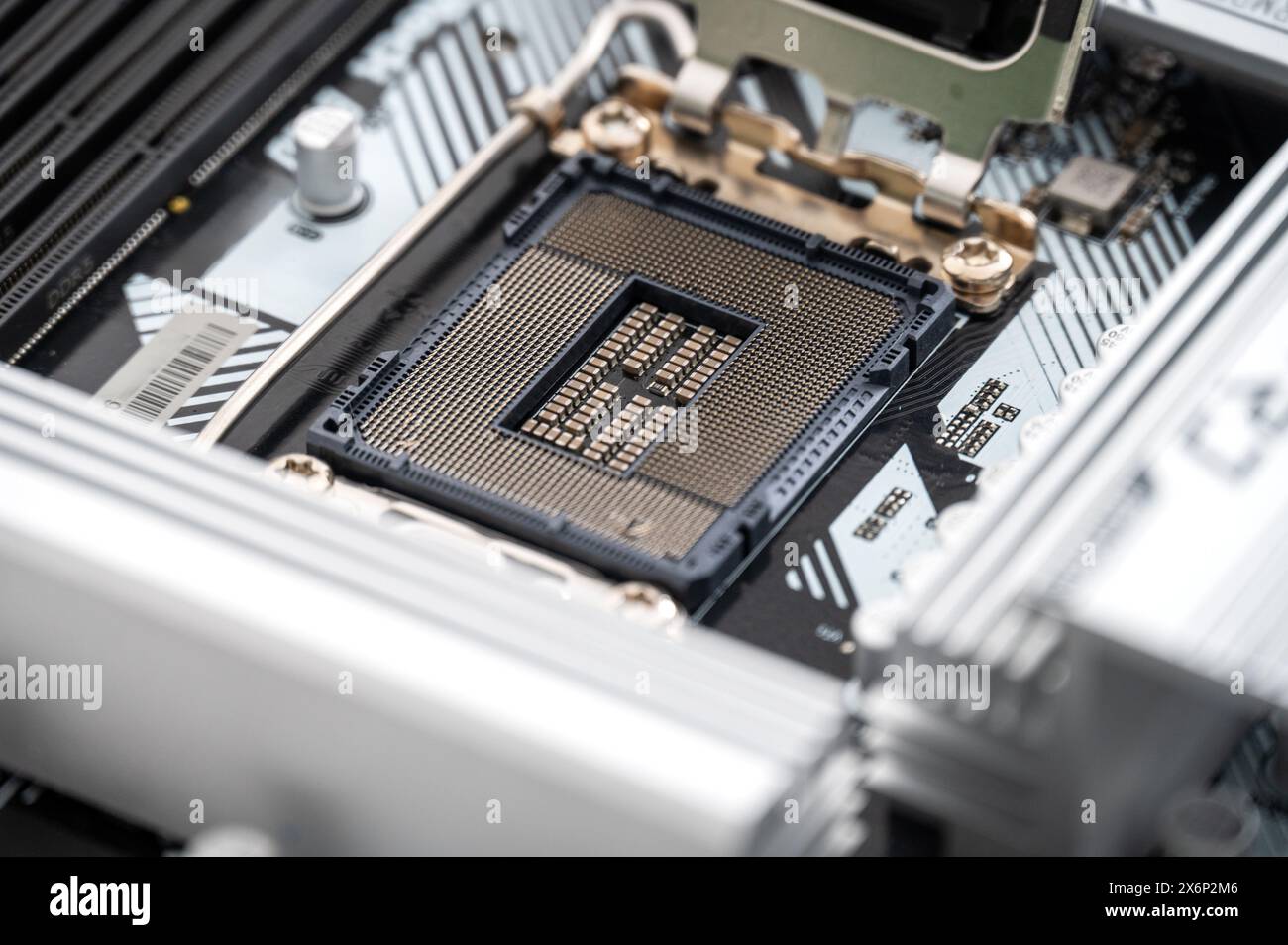 Detaillierte Nahaufnahme eines leeren CPU-Sockels auf einem schlanken, modernen Mainboard. Das Bild zeigt komplexe Technologiekomponenten, die in Advanced com verwendet werden Stockfoto