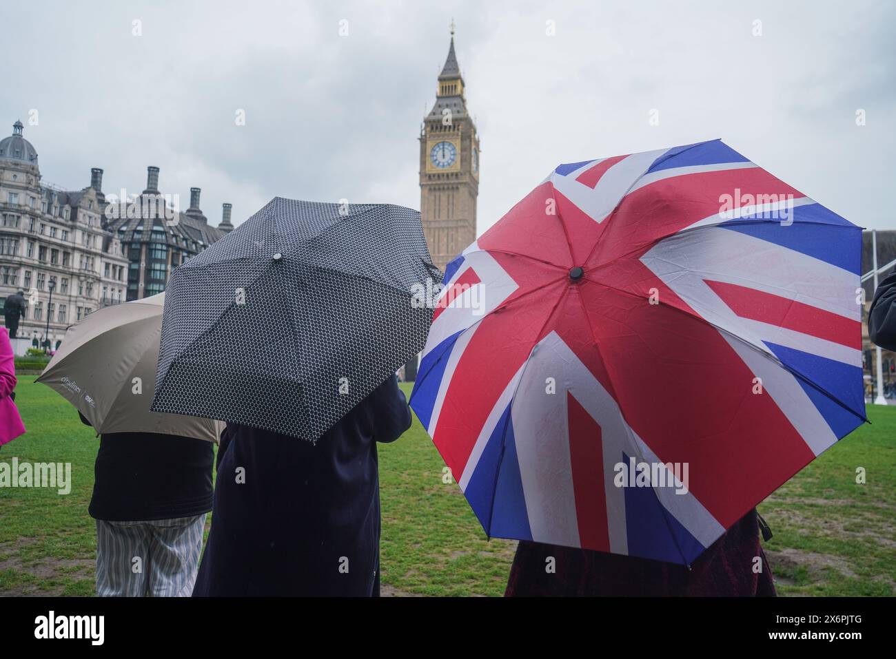 London, Großbritannien. Mai 2024. Touristen mit Unterschlupf mit Sonnenschirmen auf dem Parlamentsplatz bei leichtem Regenschauer. Quelle: amer Gazzal/Alamy Live News Stockfoto