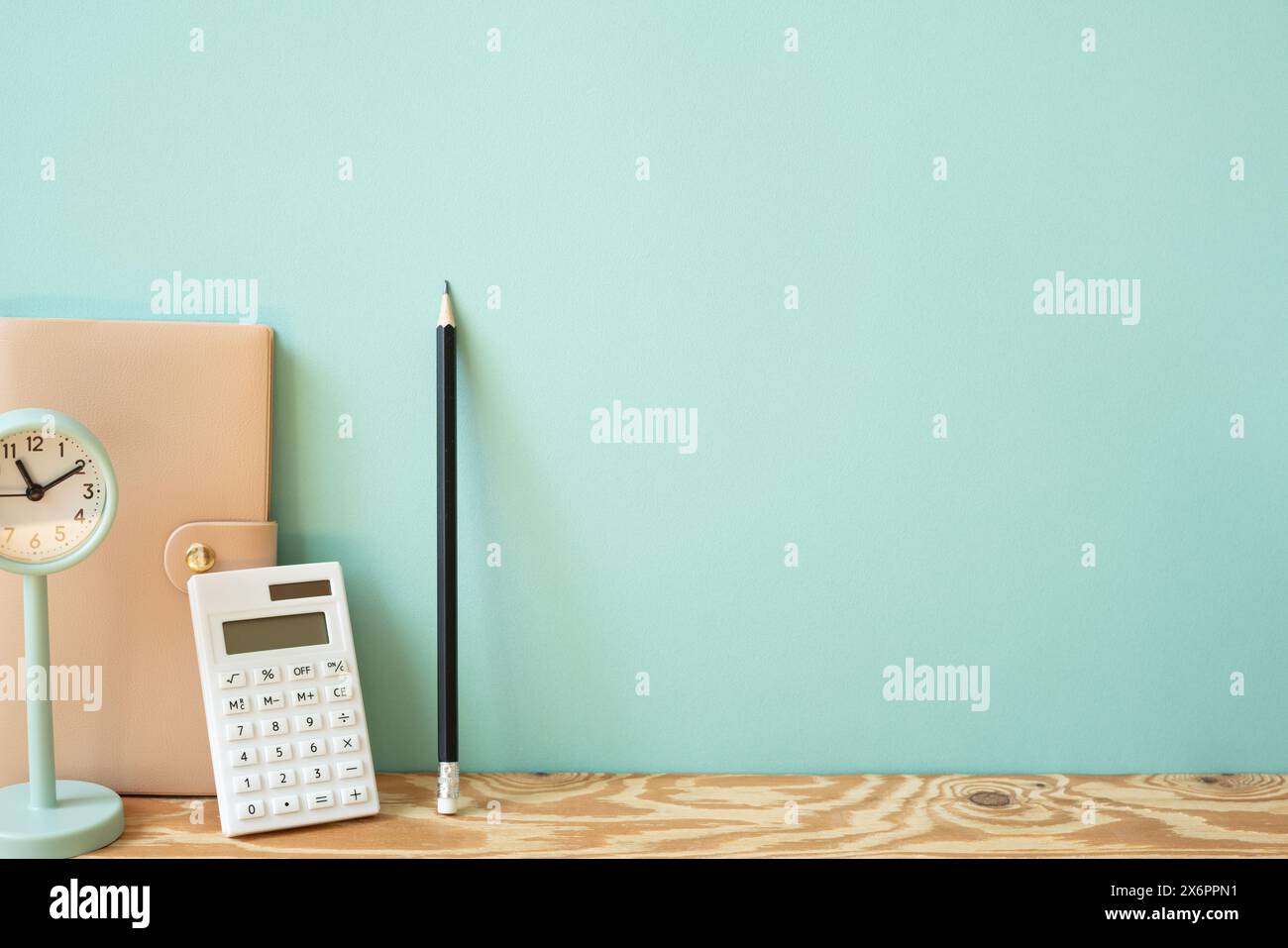 Tagebücher, Taschenrechner, Bleistift, Uhr auf Holztisch. Mint. Wandhintergrund Stockfoto