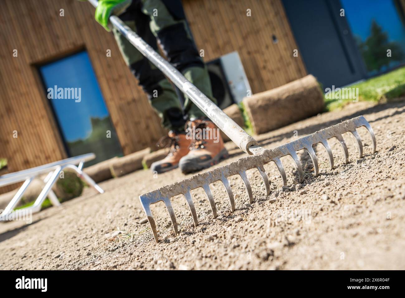 Gartenarbeiter mit Rechen zum Entfernen von Schmutz. Stockfoto