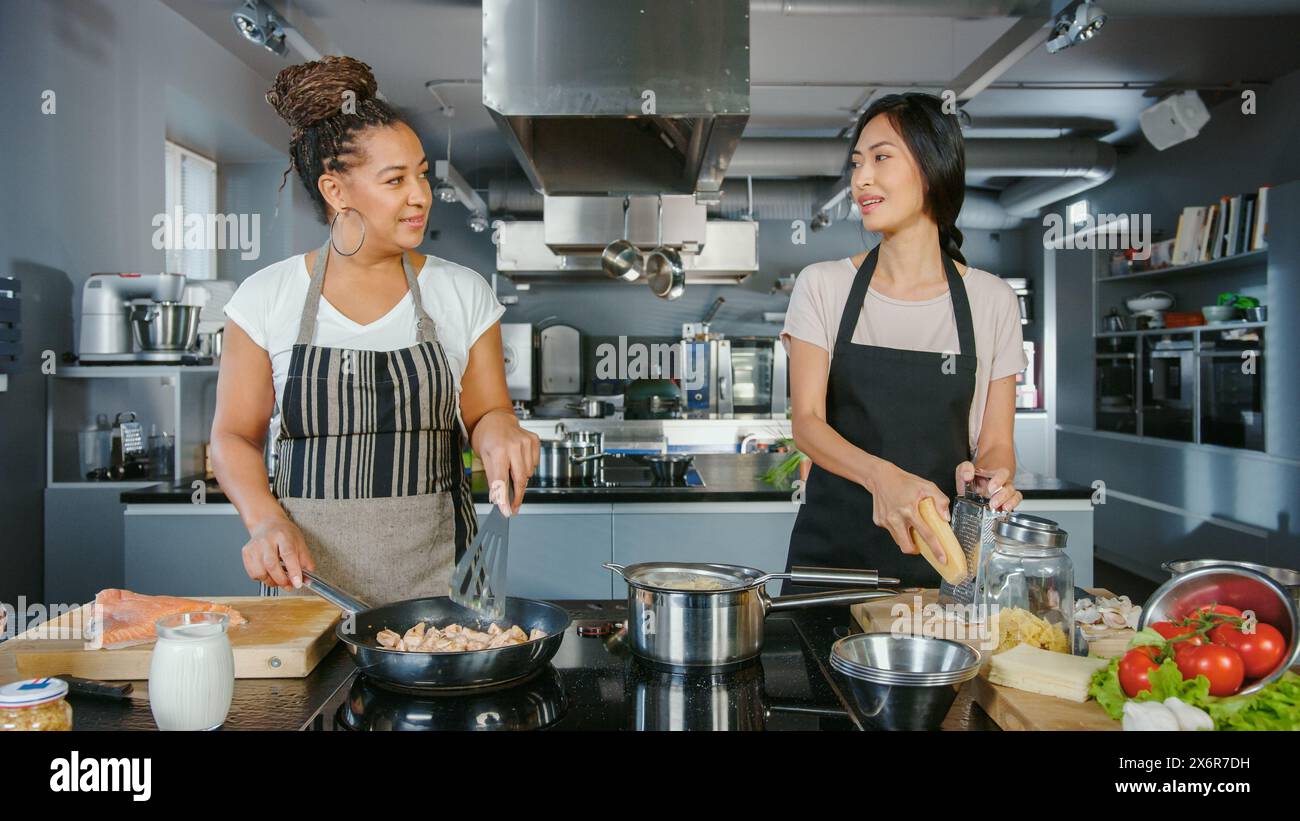 TV-Kochshow Küche mit zwei Meisterköchen. Zwei weibliche Moderatoren unterrichten das Kochen von Lebensmitteln. Profis sprechen über köstliches Rezept. Online Video Kurs der gesunden Mahlzeit Zubereitung Stockfoto