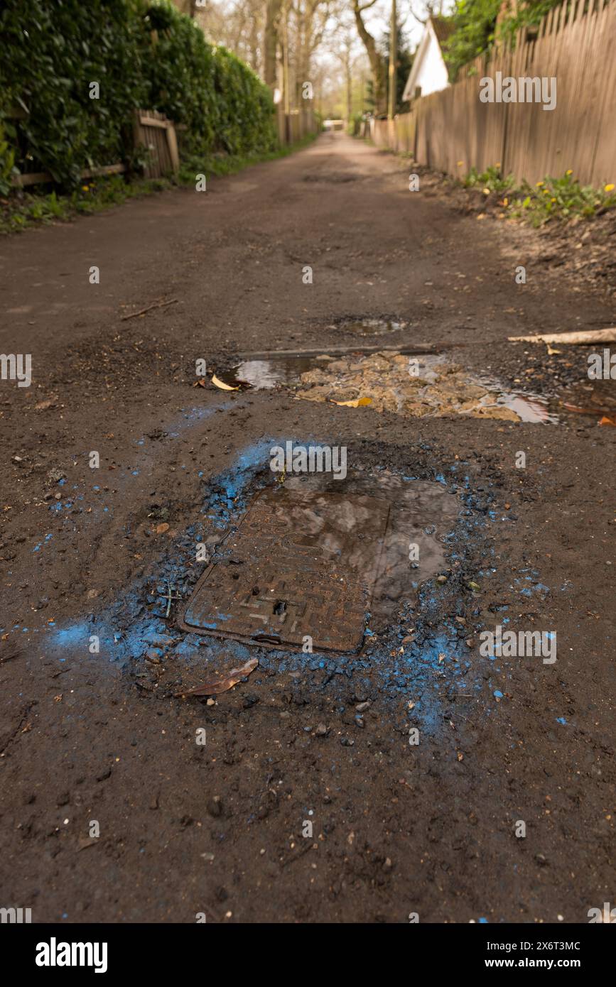 Blaue Sprühfarbe wurde erst 4 Wochen später zur Identifizierung eines Lecks im Leitungswasser verwendet, der die nicht genutzte Straße zerstörte Stockfoto