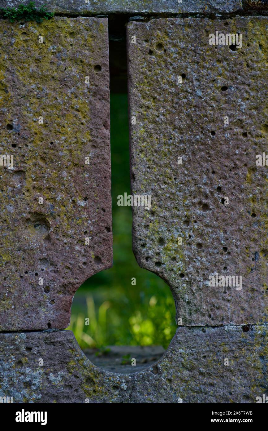 Pfeilschlitz in der Mauer einer mittelalterlichen Burg in Deutschland. Stockfoto