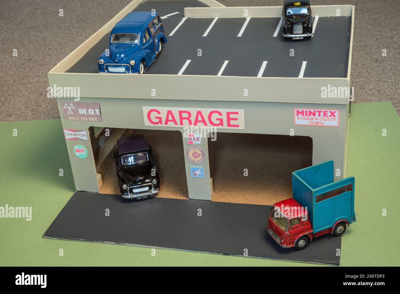 Autoreparaturgarage für Kinderspielzeuge mit Dachparkplatz mit Spielzeugfahrzeugen Stockfoto