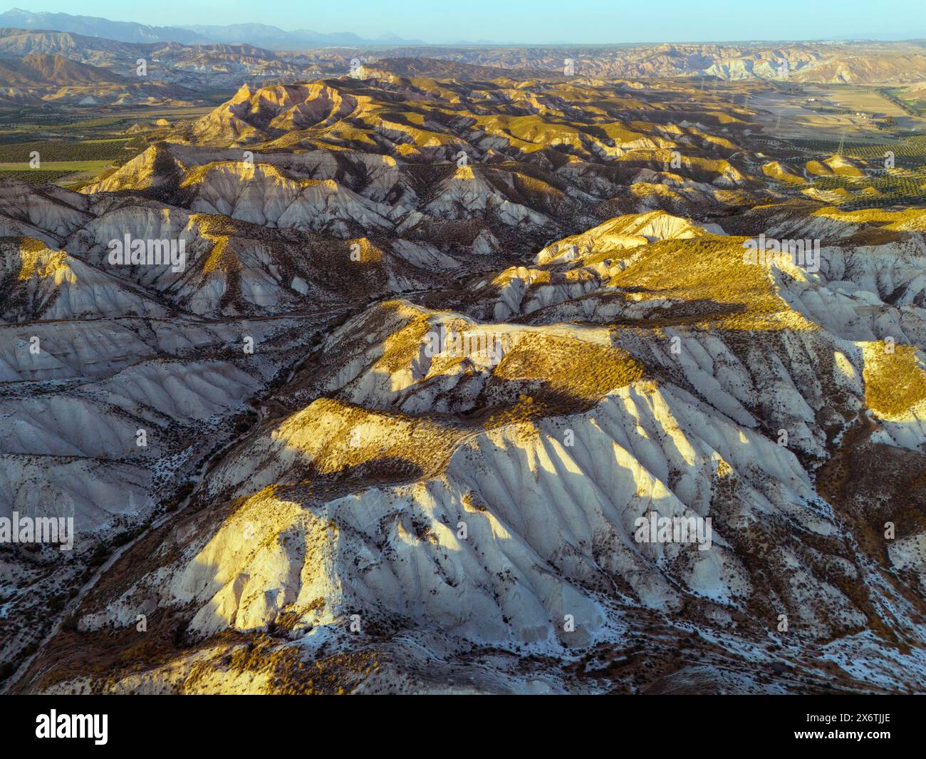 Hügelige Wüstenlandschaft in warmem Licht mit tiefen Schatten und klarer Sicht auf die geografischen Merkmale, aus der Luft, Dehesas de Guadix, Gorafe-Wüste Stockfoto