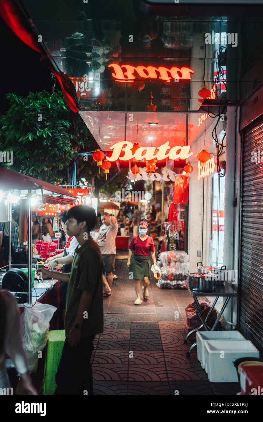 Das rot beleuchtete Schild des Restaurants auf Bangkoks Straßen in China Town beleuchtet die Nacht und dekoriert alles in einem roten Leuchten. Aufgenommen Stockfoto
