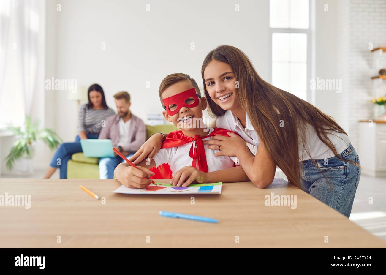 Fröhliche Geschwister Zeichnen Und Umarmen Zu Hause Stockfoto