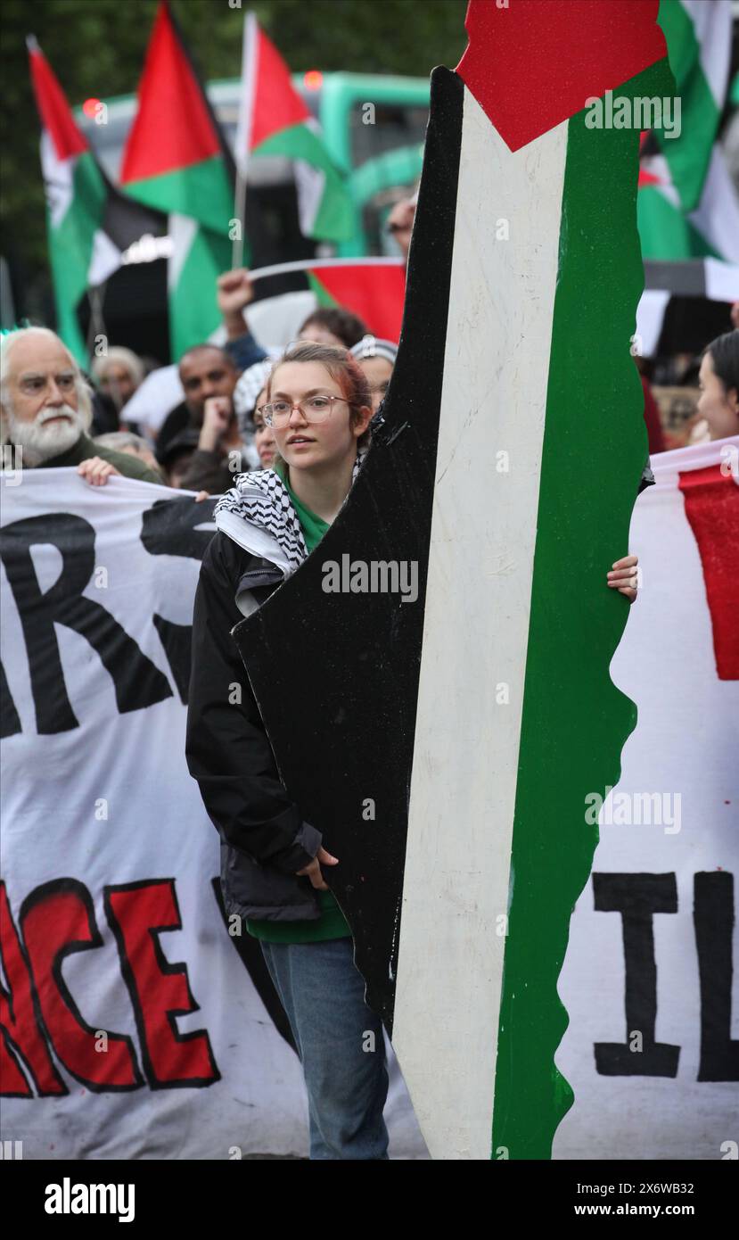 Ein Demonstrant trägt ein 10 Fuß langes Modell der Form des Palästinas von 1948, während der marsch die Stadt durchquert. Demonstranten gehen auf die Straßen von Manchester, um den 76. Jahrestag der Nakba (der Katastrophe) zu feiern, als 1948 über 700.000 Palästinenser von Paramilitärs und dem israelischen Staat aus ihren Häusern und ihrem Land vertrieben wurden. Diese Bevölkerung und ihre Nachkommen leben im Exil und versprechen, eines Tages zurückzukehren. Sie beenden die Kundgebung an der Manchester University, wo Studenten und ihre Unterstützer ein Lager des Widerstands gegen die Komplizenschaft der Universität im Curre aufgebaut haben Stockfoto