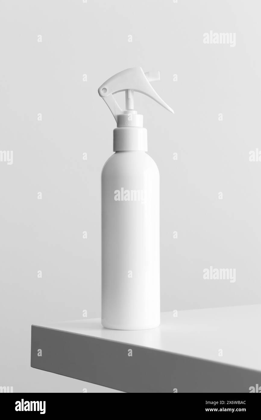 Weißes Modell der Sprühflasche für Kosmetik auf einem weißen Tisch. Stockfoto