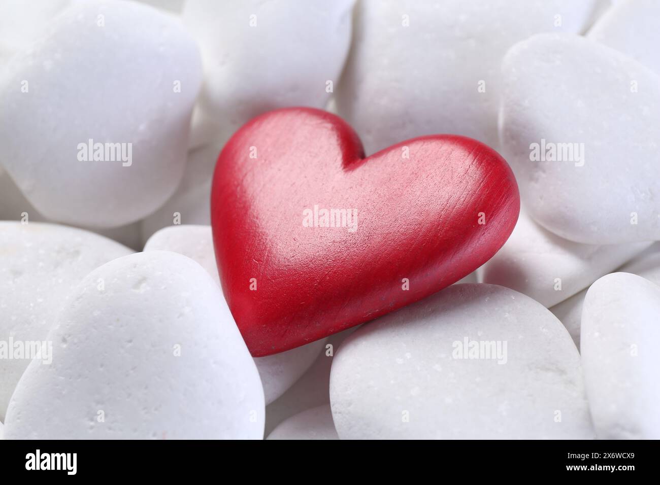 Dekoratives Herz auf weißen Kieselsteinen, Großaufnahme Stockfoto