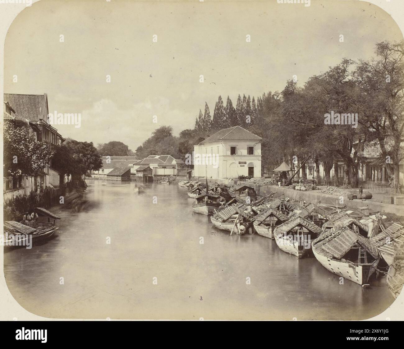 Die Kali Mas, die Kali Mas in Surabaya mit dem weißen Gebäude der Agentur Stoomvaartmaatschappij Nederland (SMN) im Zentrum. Auf der rechten Seite des Flusses eine Reihe von Pirogen. Ein Kran am Kai. Teil des Fotoalbums, das von der Soerabayasche Association of Suikerfabrikanten an Frederik Beyerinck, Einwohner von Soerabaya, präsentiert wurde., Foto, Herman Salzwedel, Soerabayasche Vereeniging van Suikerfabrikanten, Surabaya, 1876 - 1884, fotografische Unterstützung, Albumendruck, Höhe, 21,9 cm x Breite, 27,6 cm Stockfoto