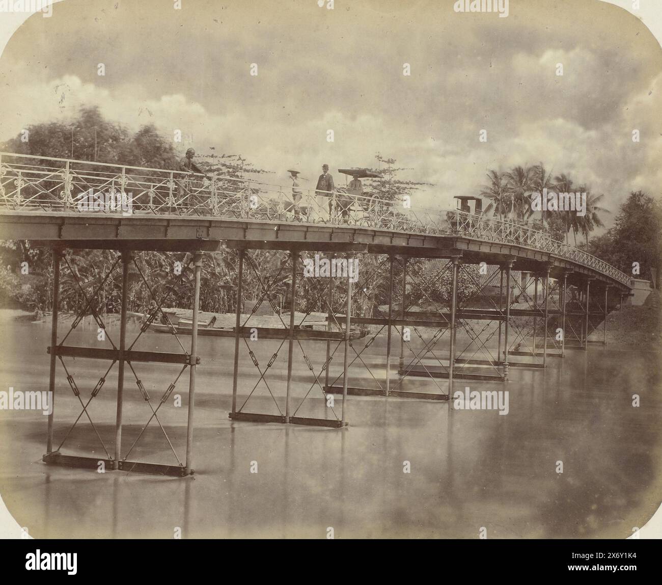 Eiserne Brücke über den Kali Brantas, eine eiserne Brücke über den Kali Brantas bei Surabaya. Ein Loading proa liegt im Fluss. Zwei Pferde und Wagen fahren auf der Brücke, sowie mehrere Javaner und ein Europäer. Teil des Fotoalbums, das von der Soerabayasche Association of Suikerfabrikanten an Frederik Beyerinck, Einwohner von Soerabaya, präsentiert wurde., Foto, Herman Salzwedel, Soerabayasche Vereeniging van Suikerfabrikanten, Surabaya, 1876 - 1884, fotografische Unterstützung, Albumendruck, Höhe, 22,3 cm x Breite, 27,8 cm Stockfoto