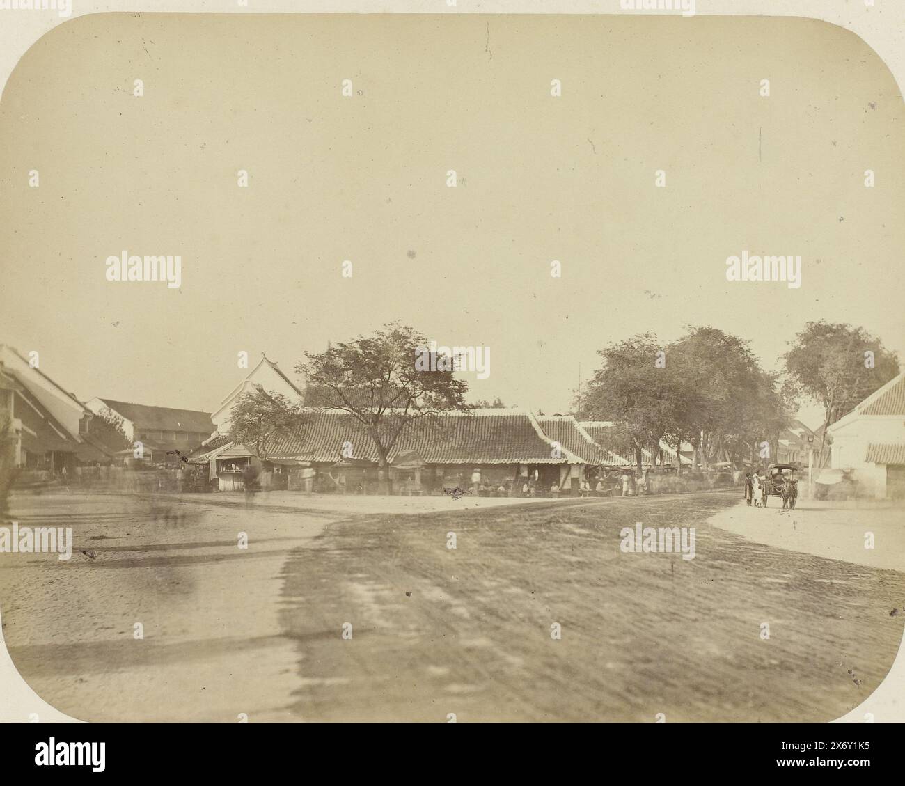 Eine Kreuzung in Surabaya, eine Kreuzung in Surabaya mit einer breiten Schotterstraße im Vordergrund, die nach links und rechts abzweigt. In der Mitte rechts ein Pferd und ein Wagen mit ein paar Leuten. Das Foto ist in der Mitte links unscharf. Teil des Fotoalbums, das von der Soerabayasche Association of Suikerfabrikanten an Frederik Beyerinck, Einwohner von Soerabaya, präsentiert wurde., Foto, Herman Salzwedel, Soerabayasche Vereeniging van Suikerfabrikanten, Surabaya, 1876 - 1884, fotografische Unterstützung, Albumendruck, Höhe, 21,7 cm x Breite, 27,8 cm Stockfoto
