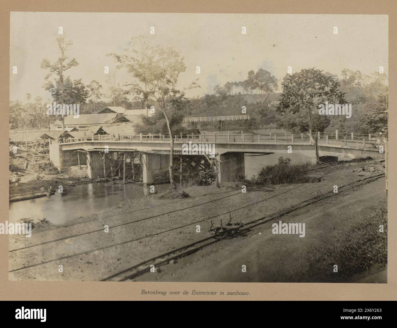 Betonbrücke über den Fluss Enim im Bau (Titel auf Objekt), Betonbrücke über den Fluss Air Enim im Bau, im Hintergrund die weiße Eisenbahnbrücke. Teil des Lose-Leaf-Fotoalbums, das die Mitarbeiter der Boekit-Asam Coal Mines in Sumatra dem scheidenden Ingenieur-Direktor H. Tromp am 7. Januar 1922 präsentierten., Foto, anonym, Boekit-Asam, 1921 - 1922, fotografischer Träger, Gelatinedruck, Höhe, 279 mm x Breite, 392 mm Stockfoto