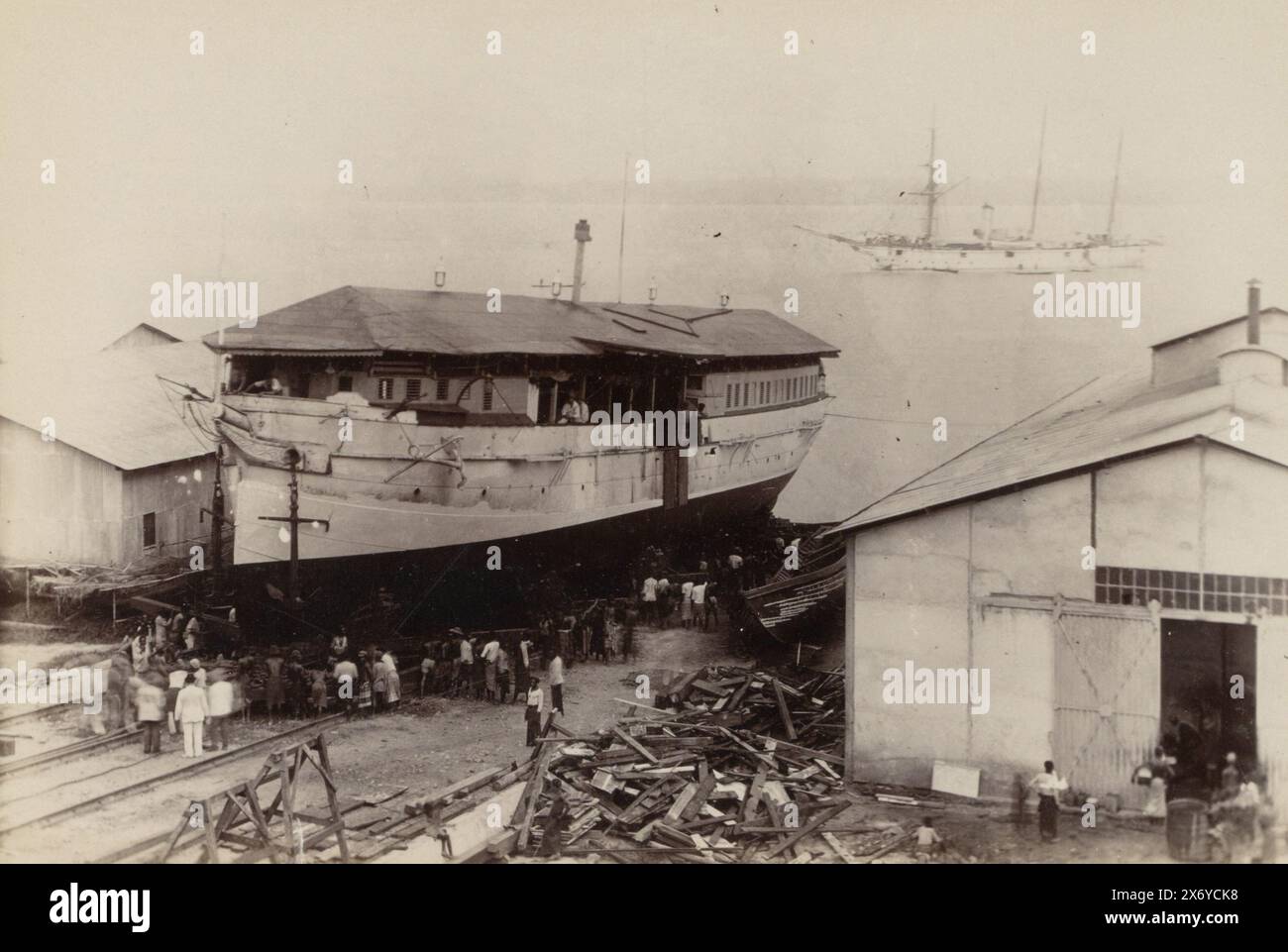 Werft in Kamerun mit den Schiffen "Cyclop" und (vermutlich) "Wolf". Die „Cyclop“ war (vermutlich) ein sogenannter „Hulk“, ein nicht seetüchtiges Schiff, das als Handelsposten diente. Teil des Fotoalbums mit Aufnahmen von Kamerun um 1899., Foto, anonym, Kameroen, 1899, Fototräger, Albumendruck, Höhe, 134 mm x Breite, 200 mm Stockfoto