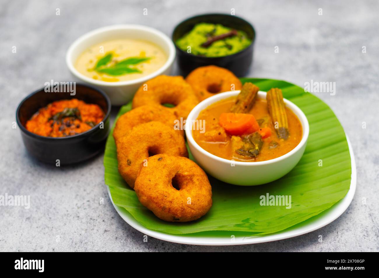 Selektiver Fokus auf das berühmte südindische Essen „Medu Vada“ mit Sambar und Kokosnuss-Chatney. Stockfoto Selektiver Fokus auf das berühmte südindische Essen „Medu Vada“ mit Sambar und Kokosnuss-Chatney. Stockfoto