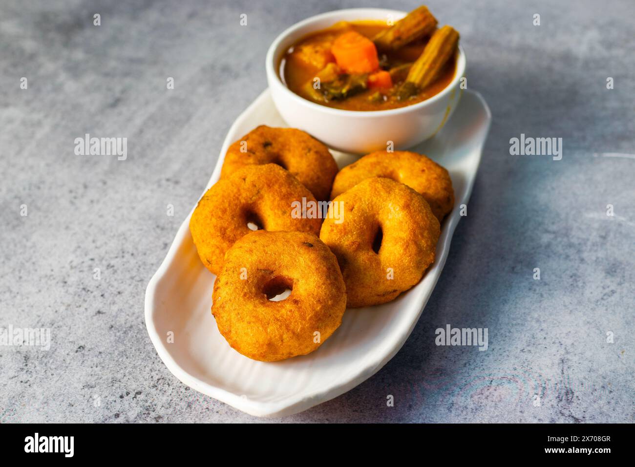 Selektiver Fokus auf das berühmte südindische Essen „Medu Vada“ mit Sambar und Kokosnuss-Chatney. Stockfoto Selektiver Fokus auf das berühmte südindische Essen „Medu Vada“ mit Sambar und Kokosnuss-Chatney. Stockfoto