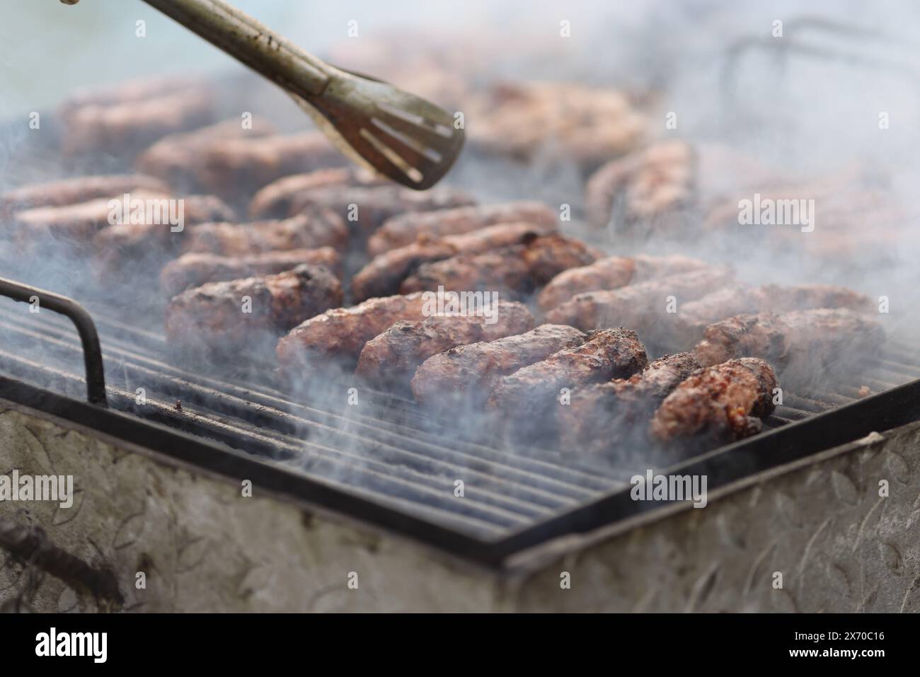 Geringe Schärfentiefe (selektiver Fokus) mit traditionellen rumänischen Mici (mititei), gegrillten Hackfleischrollen in zylindrischer Form auf dem barbe Stockfoto