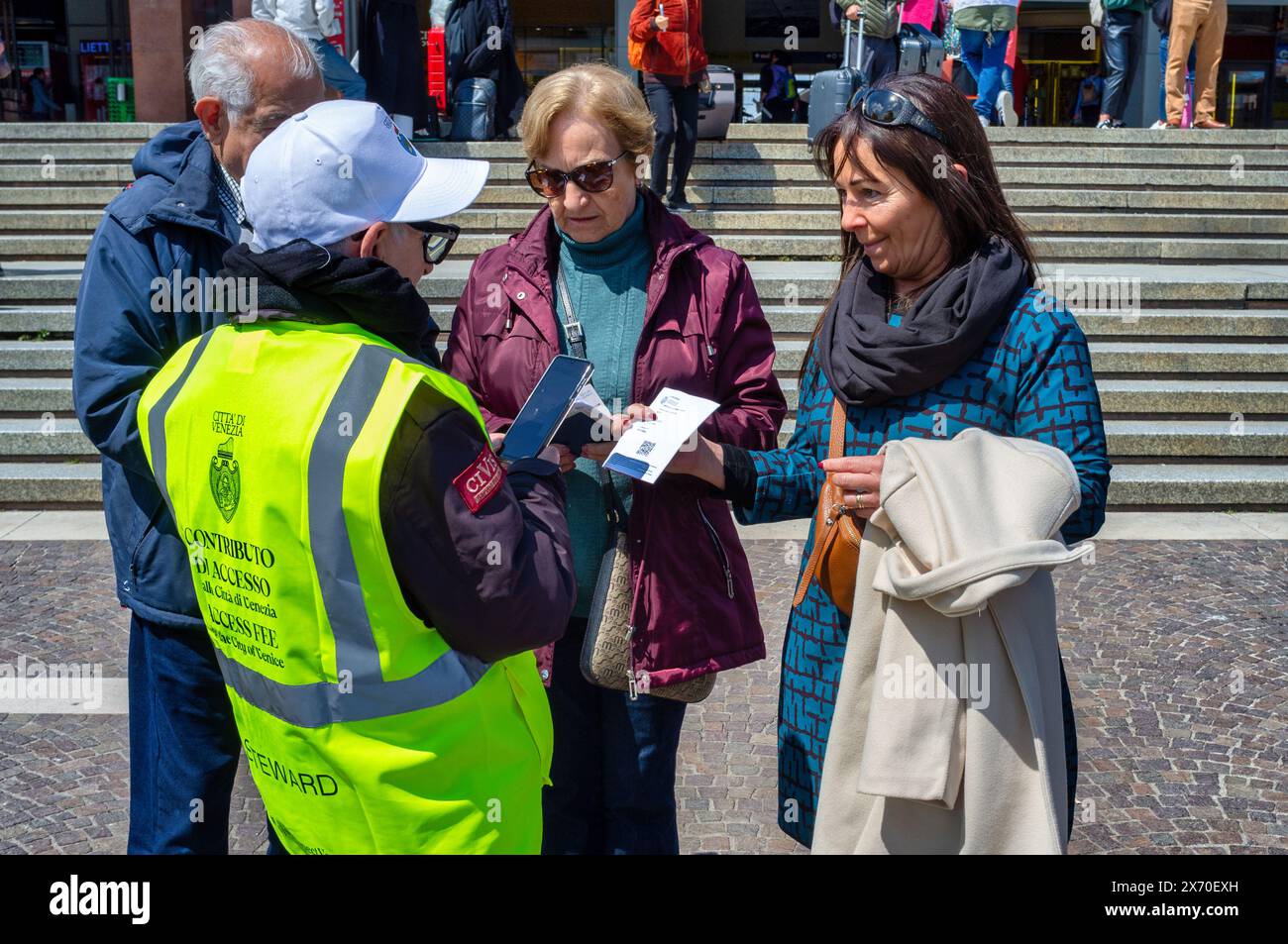 26. april 2024 Venedig, Italien: Touristen, die in Venedig ankommen, zeigen dem für die Kontrolle zuständigen Personal den neuen Stadtzugang Stockfoto