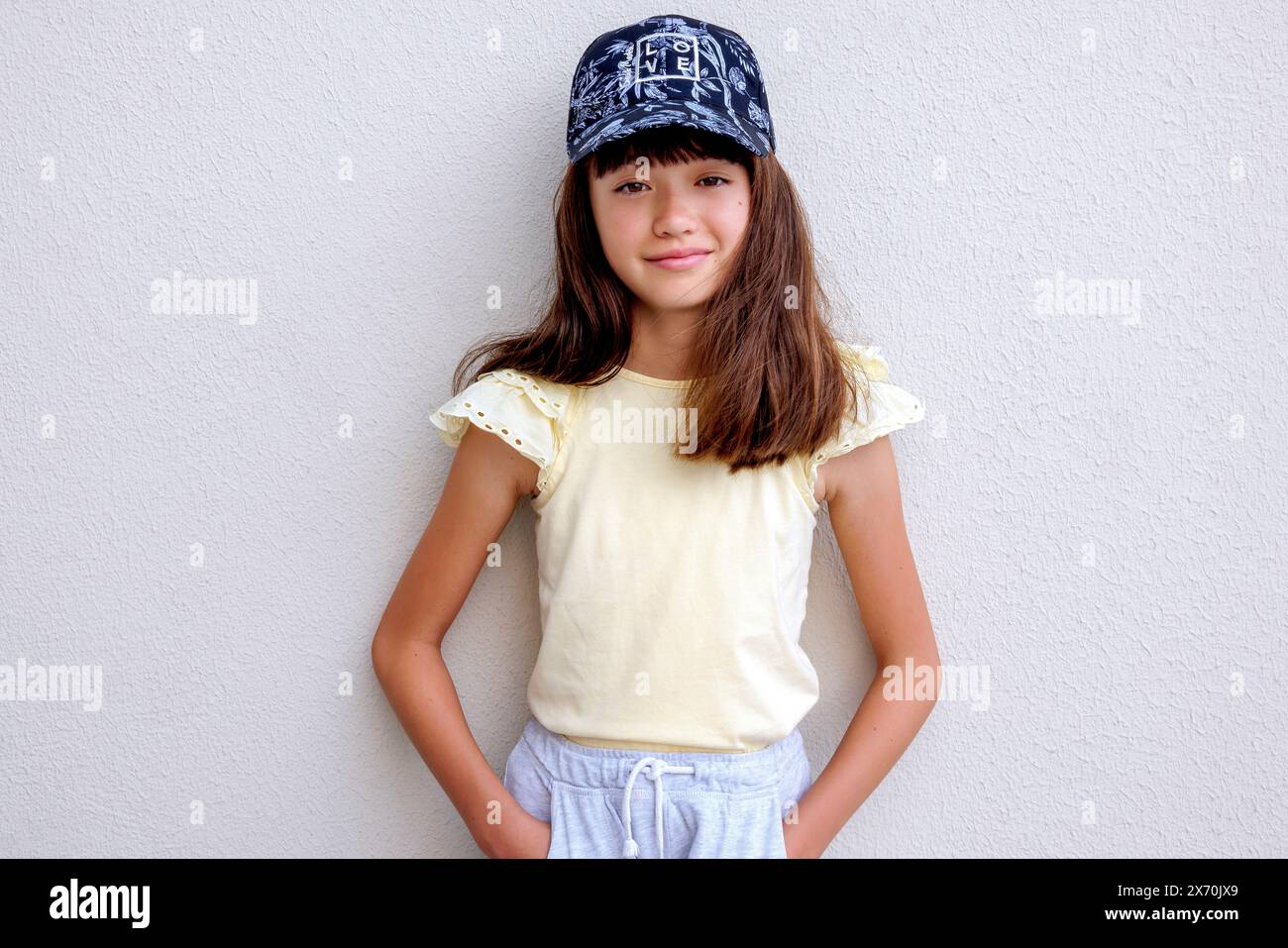 Ein schönes elfjähriges Mädchen, das eine Baseballmütze trägt Stockfoto