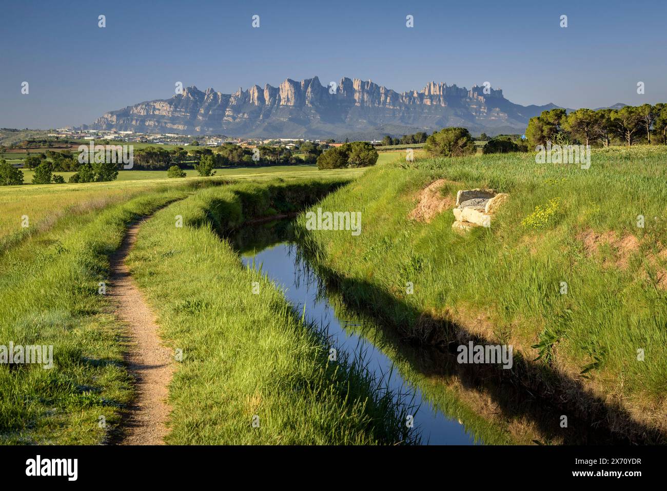 Der Kanal Séquia de Manresa und der Berg Montserrat im Hintergrund, an einem Frühlingsmorgen (Bages, Barcelona, ​​Catalonia, Spanien) Stockfoto