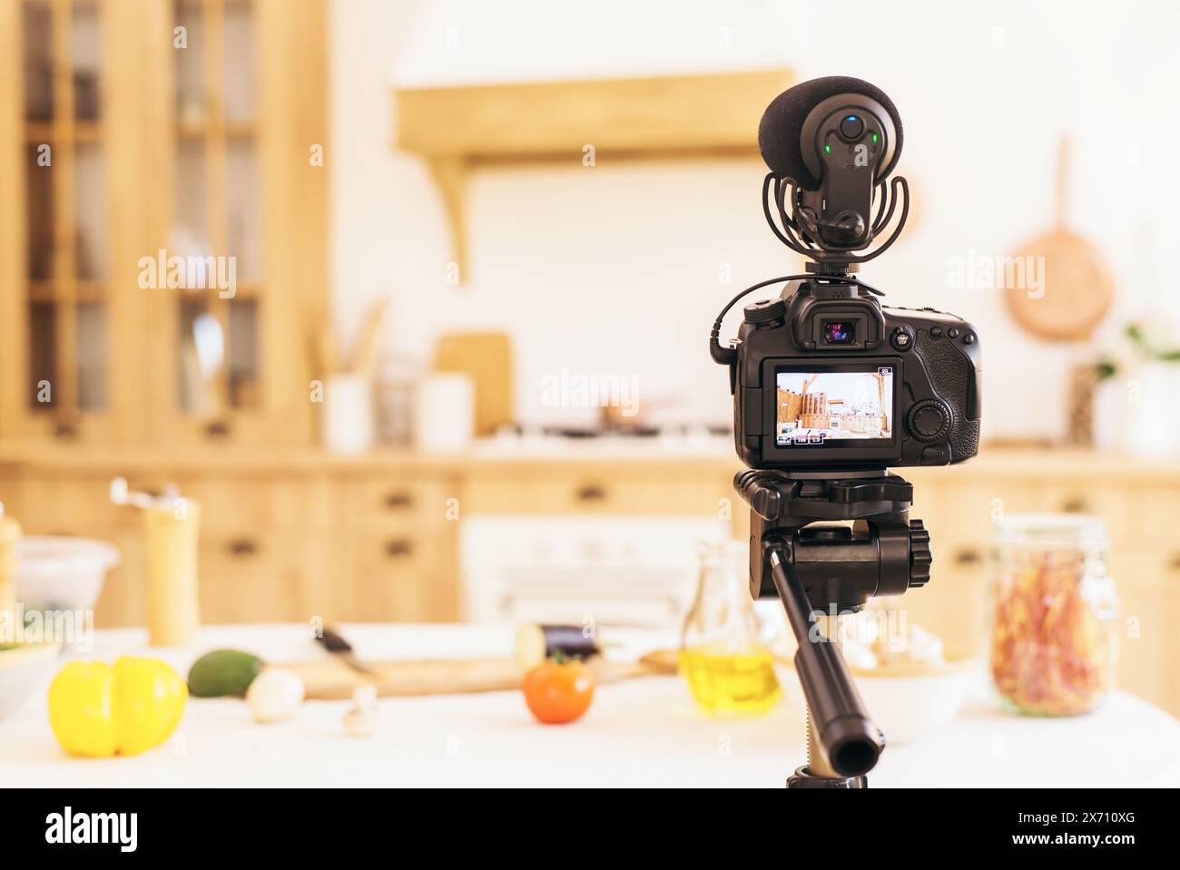 Stilvolle Küche mit minimalistischem Interieur. Professionelle Kamera macht Fotos von verschwommener Küche bei Tageslicht. Food-Blog. Stockfoto