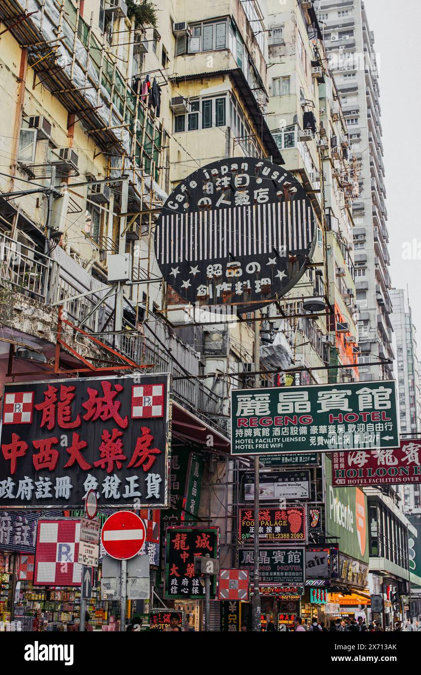 Eine der unzähligen belebten Straßen in Hongkong mit Schildern, die über dem Kopf hängen. Stockfoto