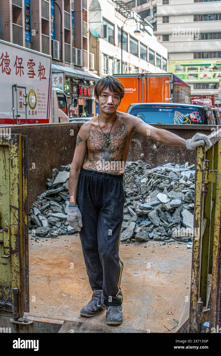 Eine Aufnahme eines tätowierten männlichen Arbeiters in hongkong Stockfoto