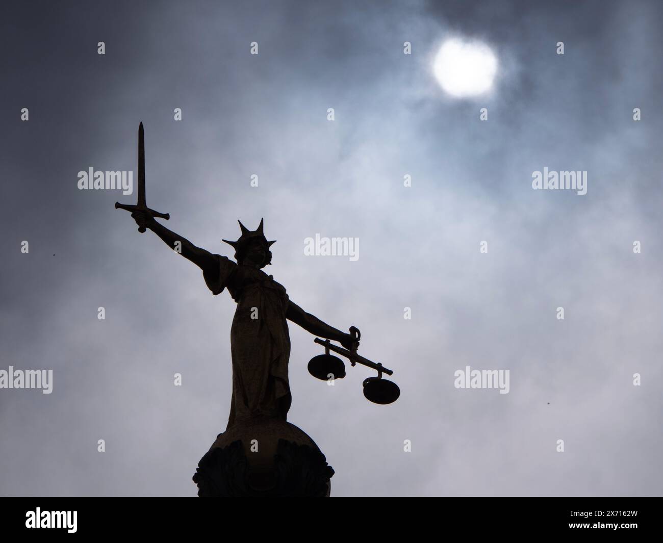 Lady Justice Statue, die ein Schwert und die Waage der Gerechtigkeit auf dem Gebäude des zentralen Strafgerichts Old Bailey mit Mond im Hintergrund in Central London, Großbritannien, hält. Stockfoto