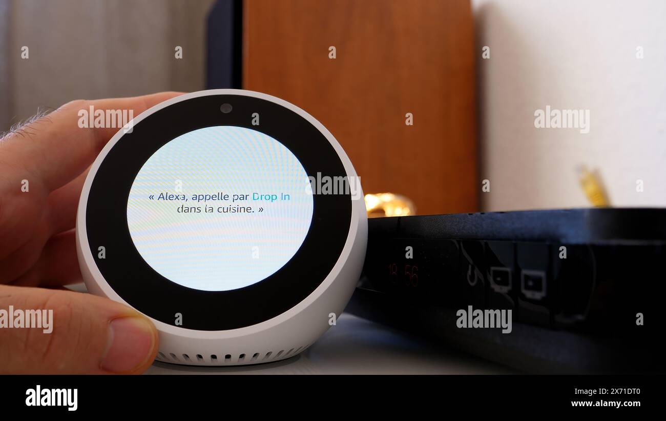 Paris, Frankreich – 5. Juni 2020: Der Amazon Echo Spot zeigt während des Einrichtungsvorgangs französische Anweisungen an, wobei eine Hand in der Nähe positioniert wird Stockfoto