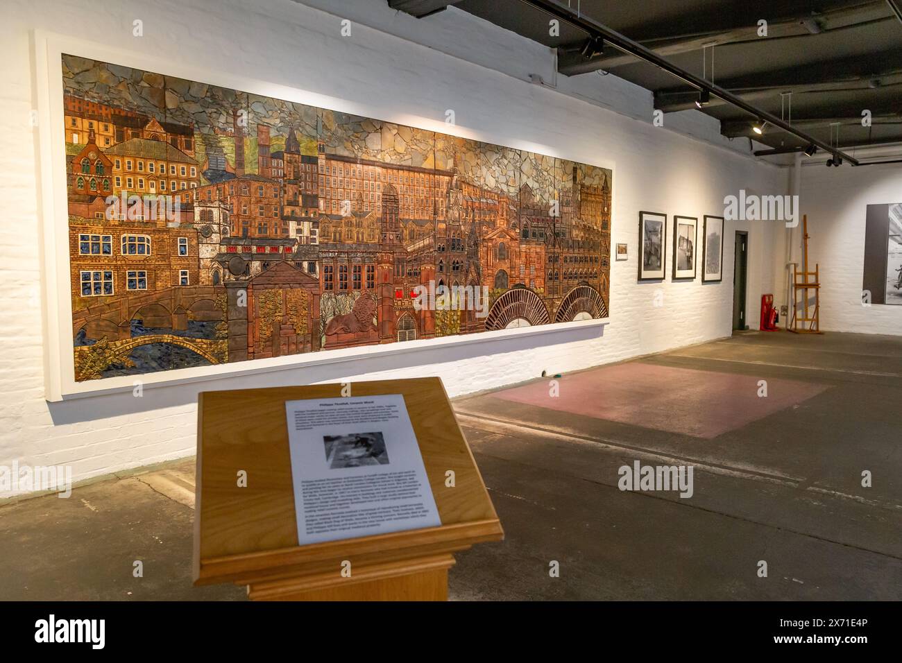 Ein Keramikgemälde von Philippa Threlfall in Salts Mill, Saltaire, Yorkshire. Das Wandgemälde zeigt bekannte lokale Gebäude. Stockfoto