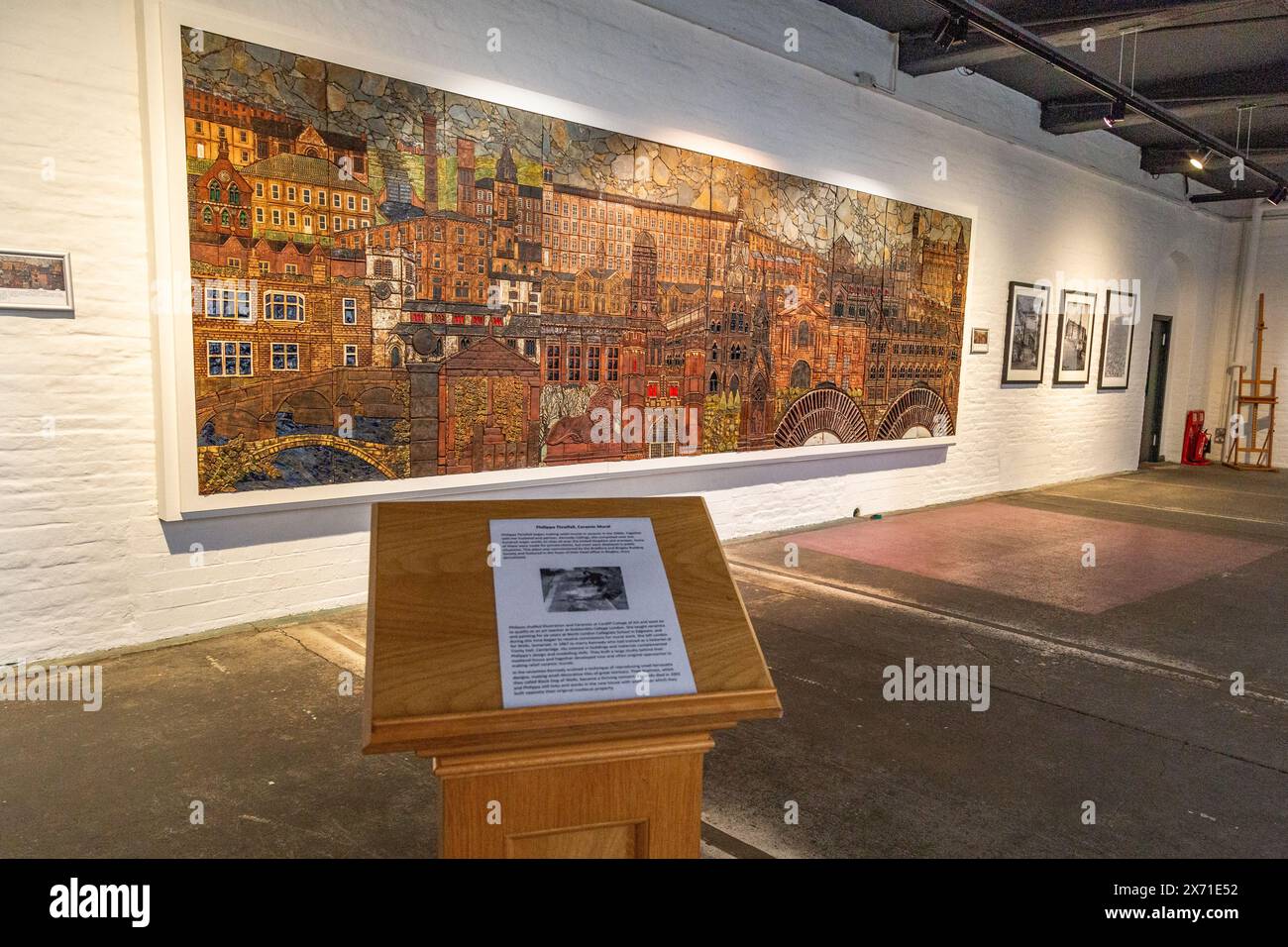 Ein Keramikgemälde von Philippa Threlfall in Salts Mill, Saltaire, Yorkshire. Das Wandgemälde zeigt bekannte lokale Gebäude. Stockfoto