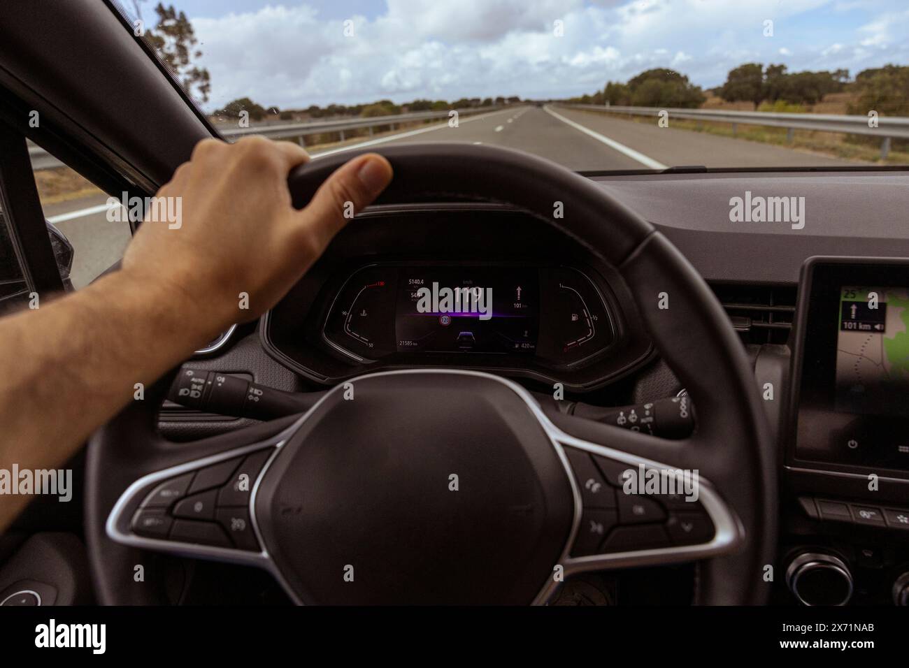 Der Blick des Fahrers auf den Tachometer bei 119 km/h auf einer Straße ist verschwommen. Blick bei Tageslicht aus dem Innenraum eines Fahrzeugs des Fahrers auf die Straßenlandschaft. Stockfoto