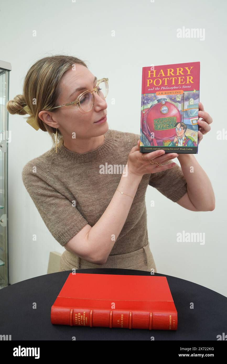 Ein Mitarbeiter hält eine erste Ausgabe von JK Rowlings Harry Potter and the Philosopher's Stone, eine von nur 500 Exemplaren, die 1997 in der ersten Auflage produziert wurden, in der Saatchi Gallery in London, Teil der ersten Buchmesse in London, ausgestellt. Bilddatum: Freitag, 17. Mai 2024. Stockfoto