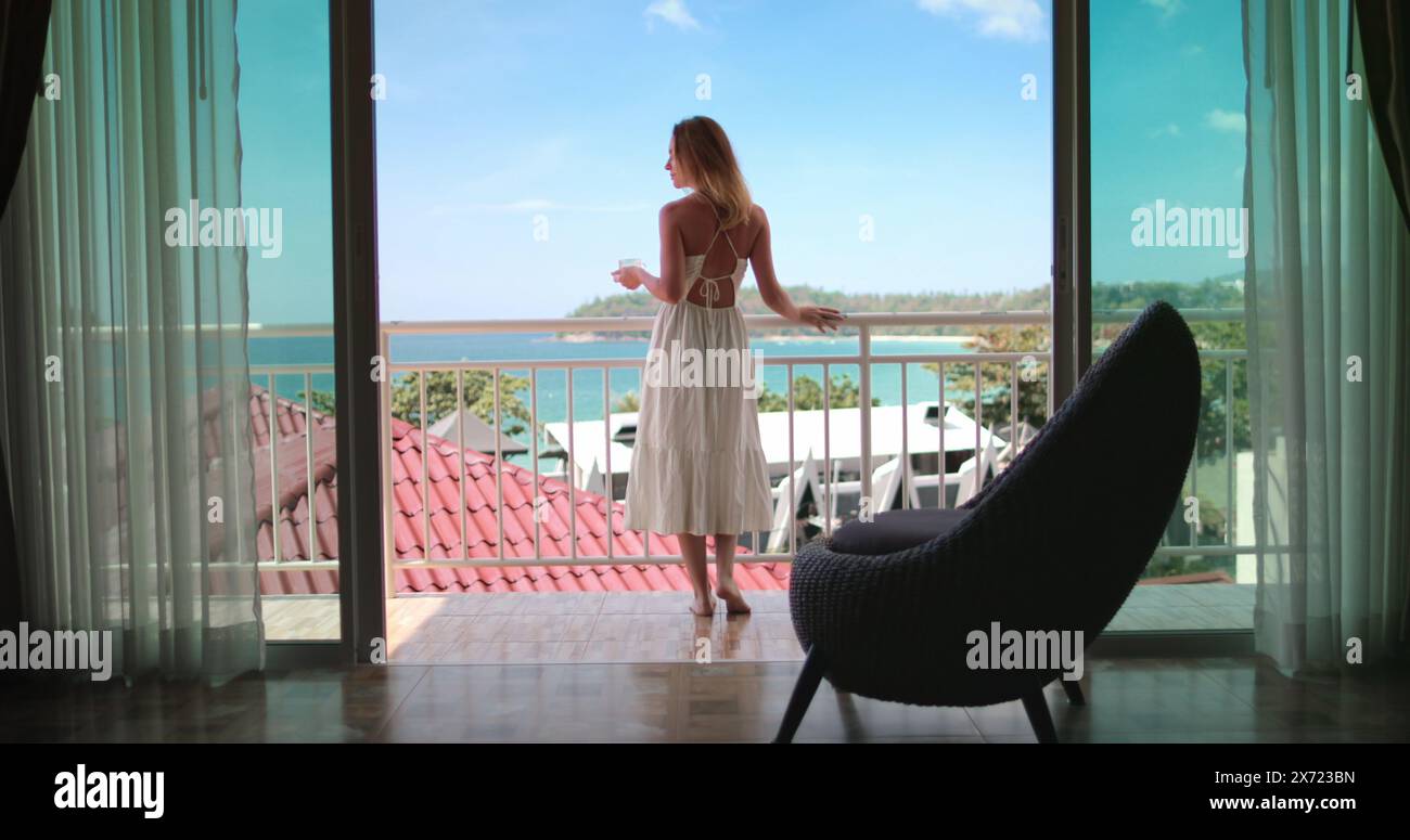 Touristen weibliche trinken Morgenkaffee auf Balkon Terrasse exotisches Resort Hotel genießen Meerblick. Elegantes Mädchen, entspannen Sie sich in Phuket, Thailand. Outdoor Lifestyle Reise Sommerurlaub auf tropischer Insel. Stockfoto