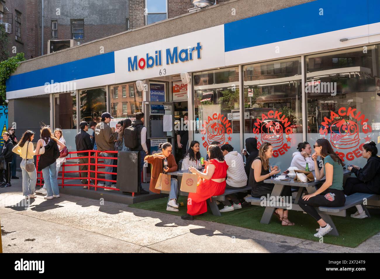 FOMO hält fest, wie die Linie vor Smacking Burger aussagt, die sich in einer Mobil-Tankstelle in Greenwich Village in New York befindet und am Samstag, den 11. Mai 2024 gesehen wurde. Die beliebte Burgergemeinde befindet sich in einem Mobil Mart im West Village und zieht einen Kult an, der Generäle Z’ers folgt, die Angst haben, die Tankstelle schtick zu verpassen. (© Richard B. Levine) Stockfoto