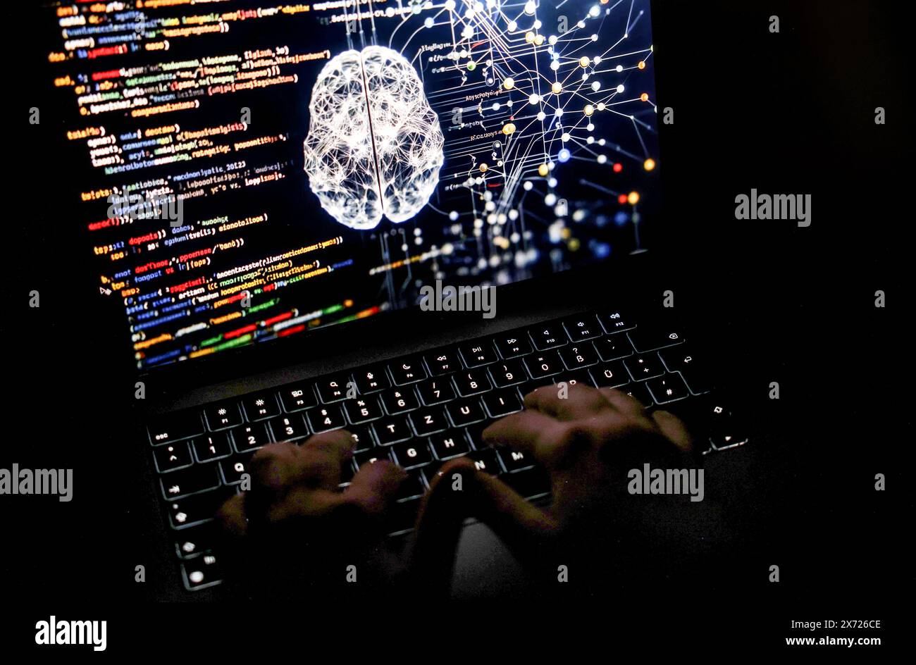 Köln, Deutschland. Mai 2024. Eine Person arbeitet an einem Computer mit einem illustrativen Bild, das von künstlicher Intelligenz auf dem Bildschirm erzeugt wird und Code aus verschiedenen Programmiersprachen und ein neuronales Netzwerk-Diagramm zeigt. Auf dem Treffen der Telekommunikationsminister am 21. Mai wird erwartet, dass die EU-Länder endlich das KI-Gesetz in der EU annehmen. Das Europäische Parlament hatte bereits im Vorfeld grünes Licht für das Projekt gegeben. Quelle: Oliver Berg/dpa/Alamy Live News Stockfoto