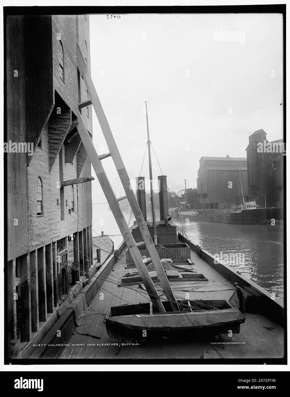 Entladung von Weizen in Aufzüge, Buffalo, Detroit Publishing Co.-Nr. 011477., Geschenk; State Historical Society of Colorado; 1949, Weizen. , Getreideaufzüge. , Piers & Kais. , Versand. , Usa, New York (Bundesstaat), Buffalo. Stockfoto